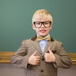 Cute pupil dressed up as teacher in classroom at the elementary school